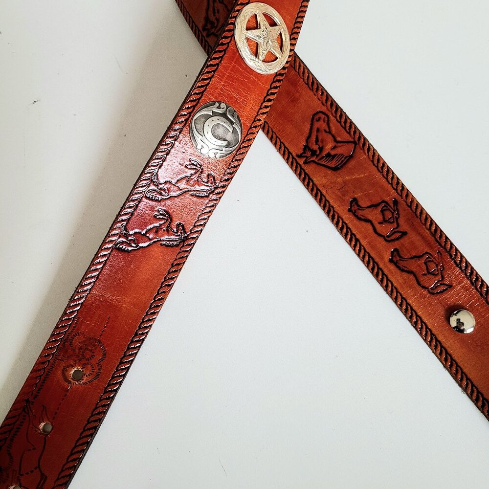 Handmaid McNeill leather belt Western design with horses and metal details.